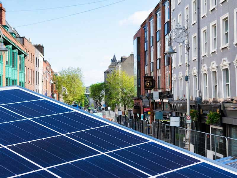 Close up of solar panels with the city of Dublin, Ireland in the background.