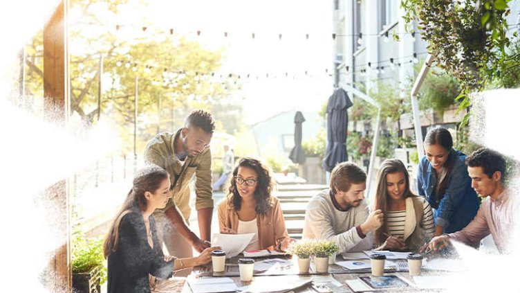 Employees working together in a cafe while having coffee