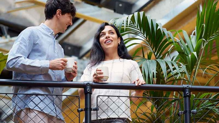 A man and woman holding coffee mugs