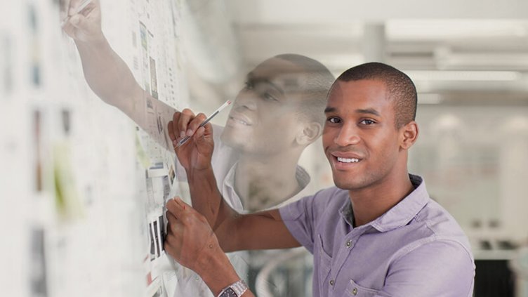 Employee writing note on sticky notes in whiteboard