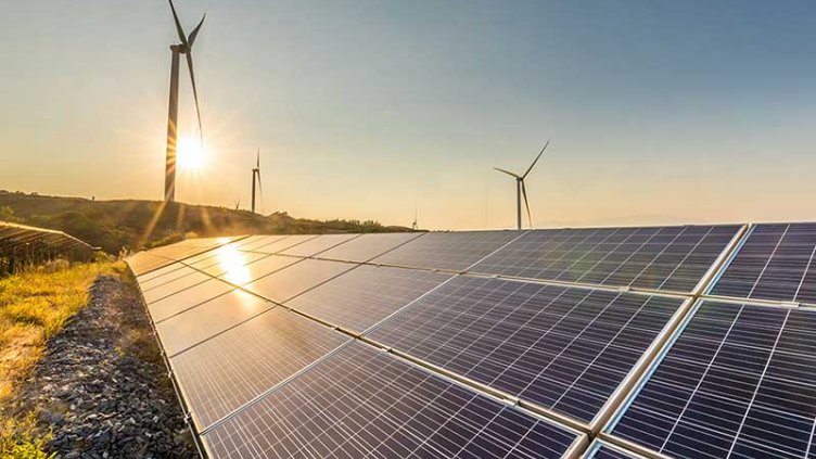 View of solar panel and wind turbines during sunrise