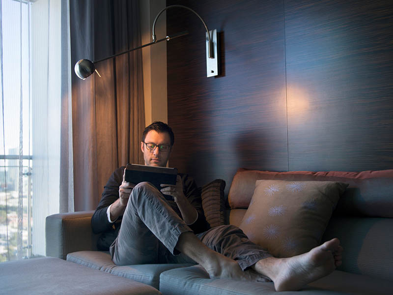 A man working on his tablet inside a hotel room