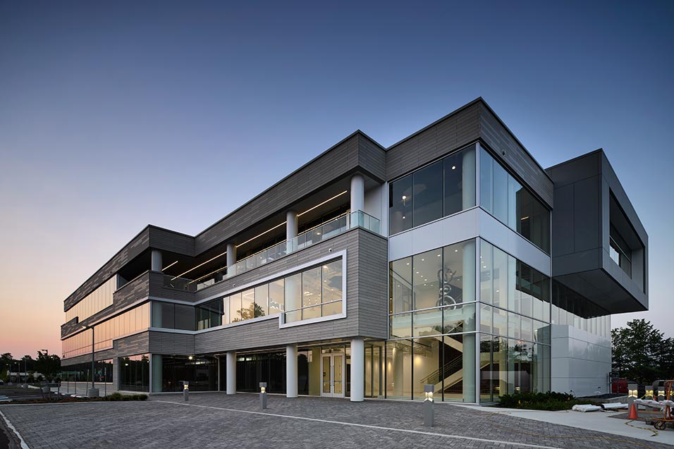 Side view of office building and office window line at dusk.